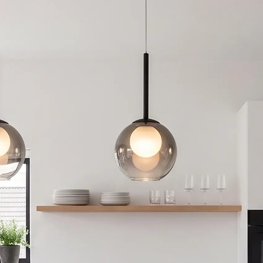 Nahaufnahme einer rauchgrauen Glaskugel-Pendelleuchte über einem Holzregal mit Tellern und Gläsern 11