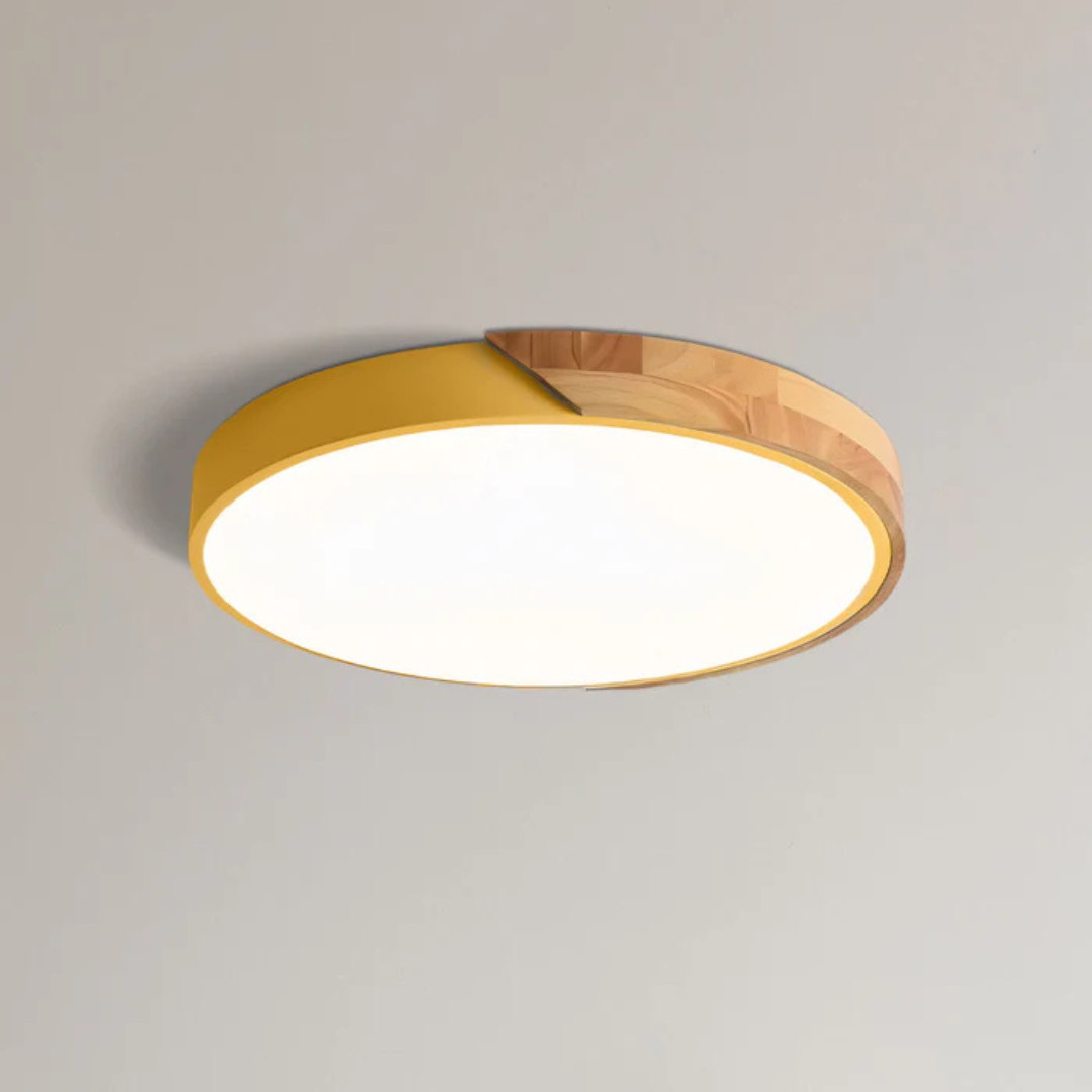 Gelbe flache Aufbauleuchte mit Holzsegment, freigestellt von schräg unten an einer hellen Decke 14