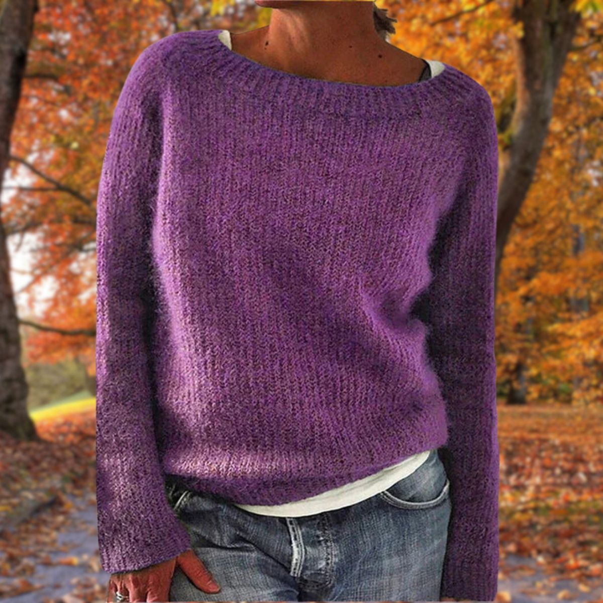 Violetter Strickpullover mit lockerer Passform, von einer Frau mit weißem Shirt und Jeans im herbstlichen Park getragen. 7