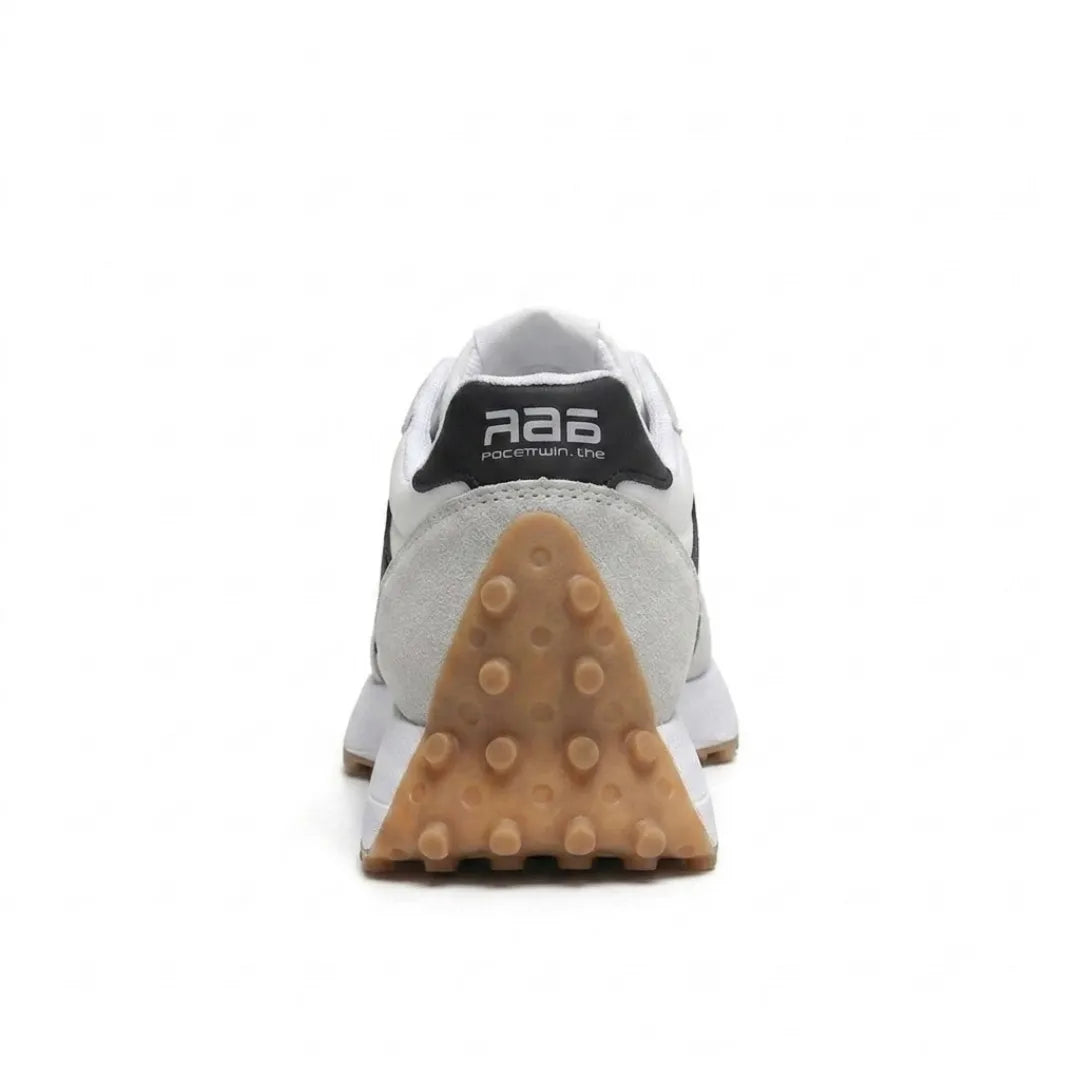 Rückansicht des Sneakers mit schwarzer Fersenkappe, hellgrauem Wildleder und dreieckig genoppter Gummisohle 25