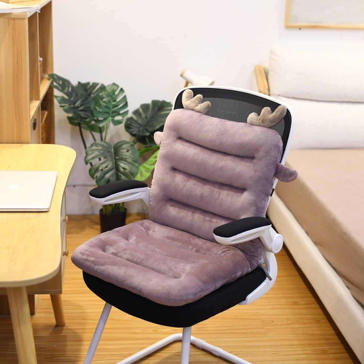 Ergonomischer Bürostuhl mit lila Plüschkissen und Rentiergeweih, modernes Home-Office-Design.