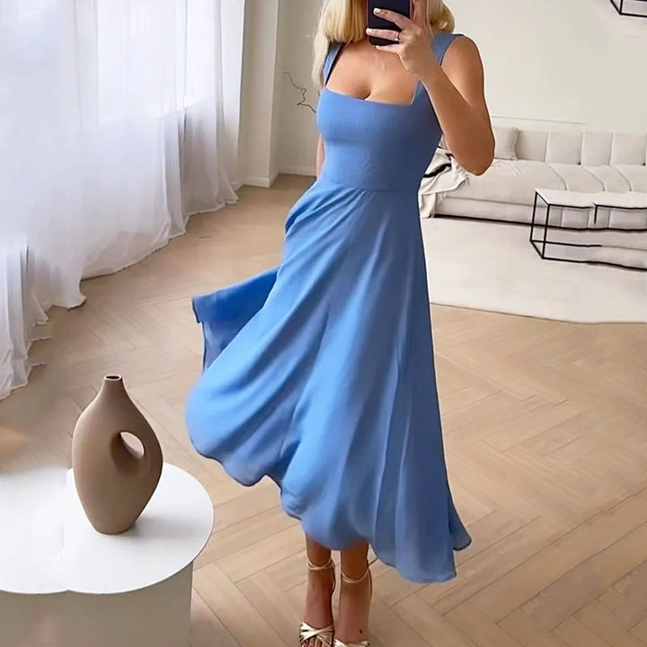 Frau in blauem Sommerkleid, schwingend, in modernem Wohnzimmer, elegante Mode, Holzfußboden.