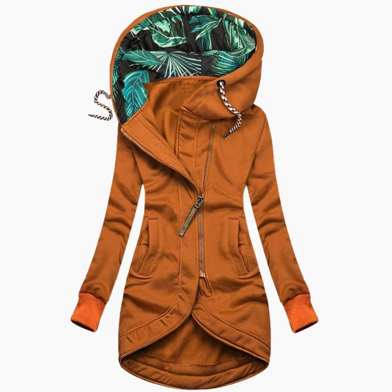 Orangebraune Variante der Jacke mit farblich passenden Bündchen, asymmetrischem Reißverschluss und Blätterdruck im Kapuzeninneren, Vorderansicht.