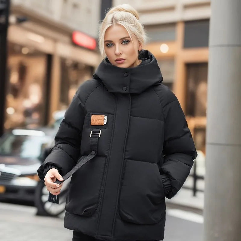 Frau in schwarzer Winterjacke mit Kapuze, warm, winddicht, modisch, Stadtumgebung.