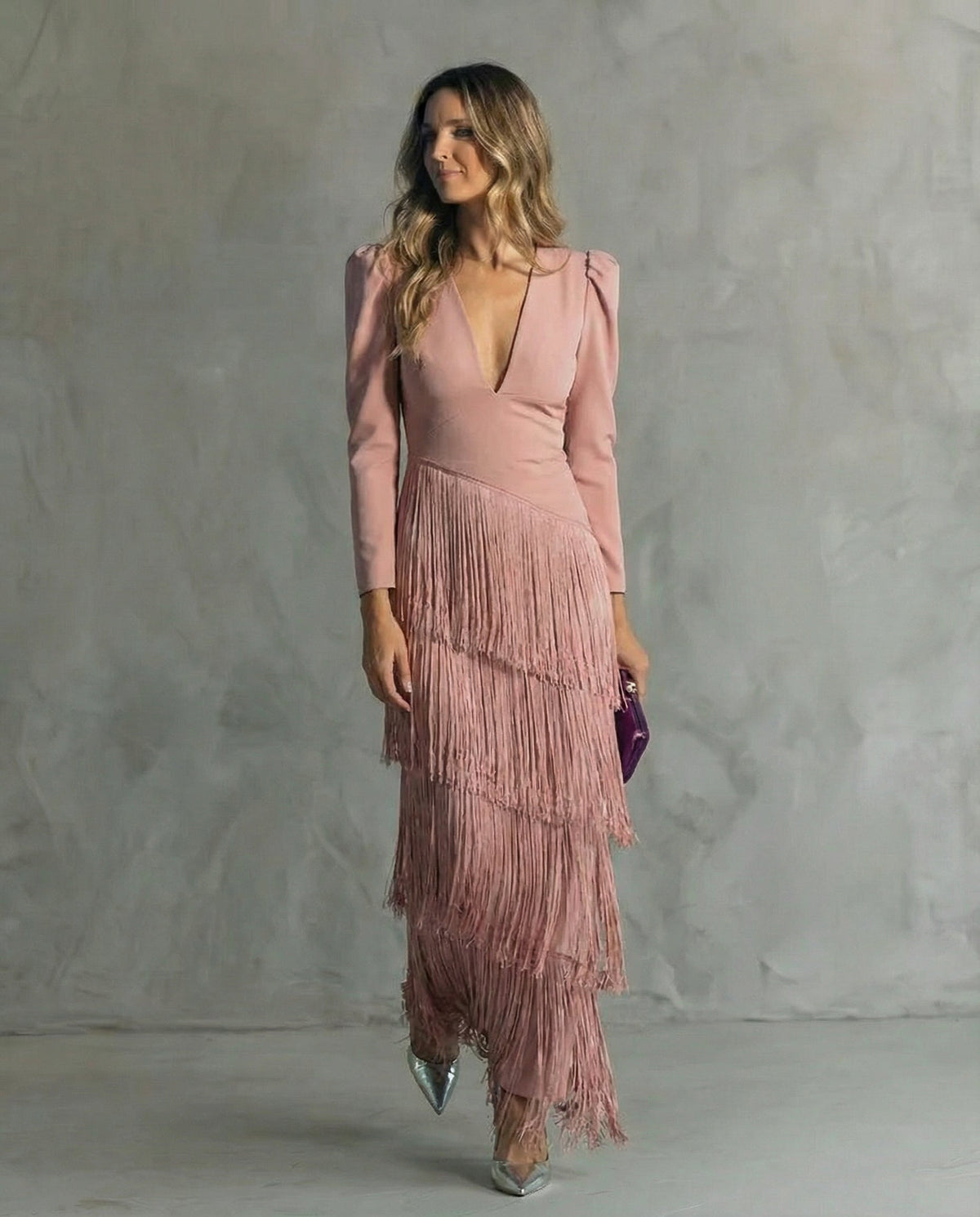 Frau im rosafarbenen Fransenkleid mit langen Ärmeln, silbernen Pumps und lila Clutch 7