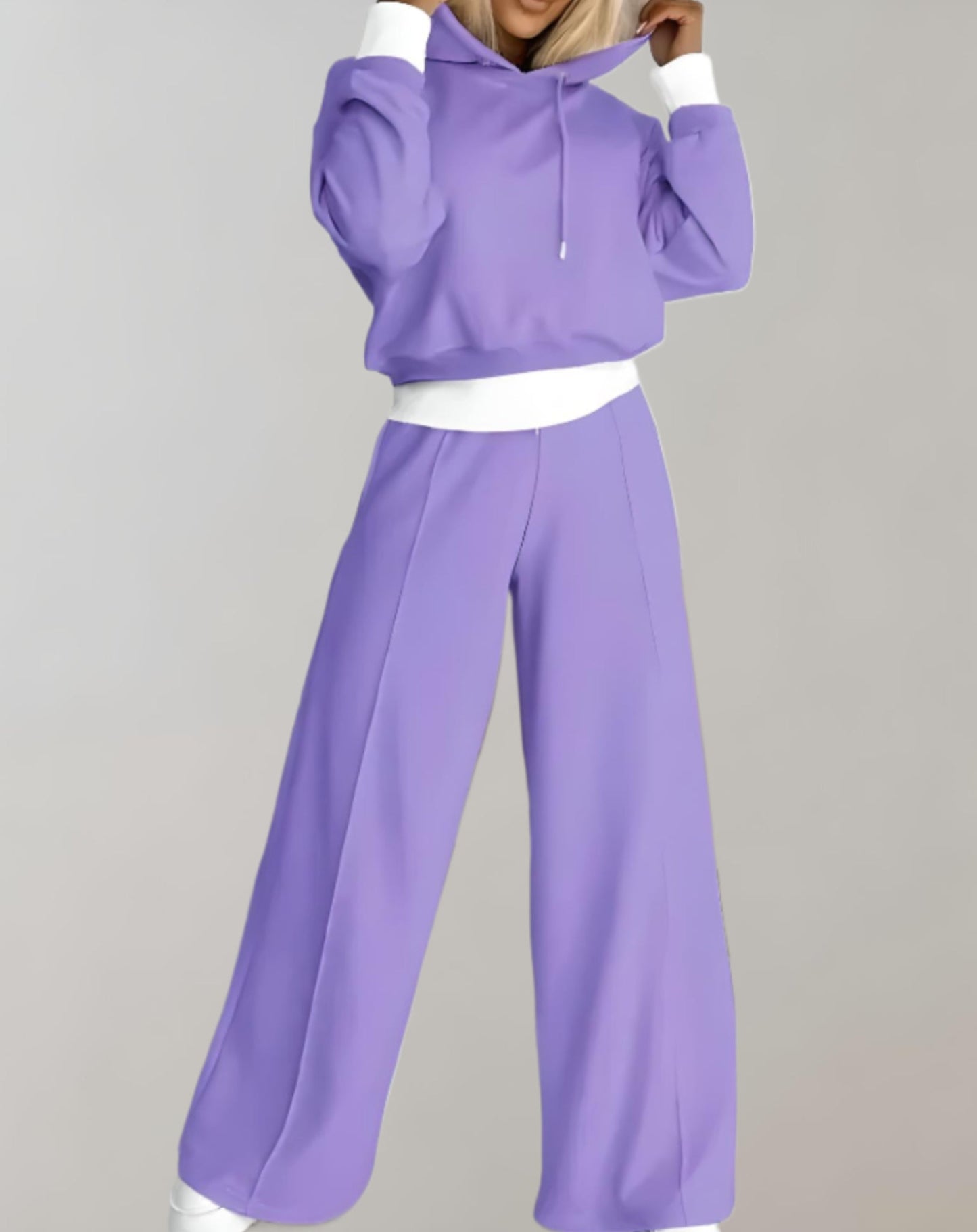 Frau in lila Jogginganzug, Kapuzenpullover und weite Hose, Freizeitmode, bequemes Outfit.