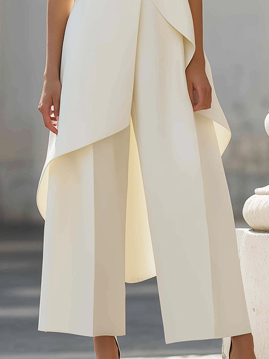 Detailaufnahme der cremeweißen Hose mit weitem Bein und Bügelfalte, darüber der fallende Saum des Oberteils. 12