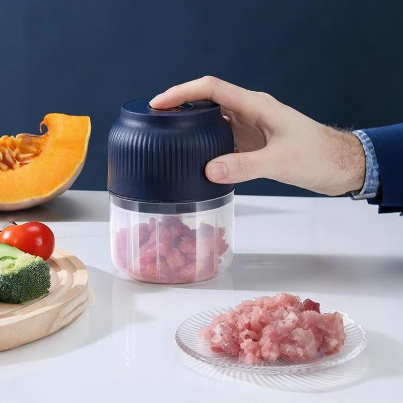 USB-wiederaufladbarer Mini-Zerkleinerer in Dunkelblau mit transparenter Schüssel und Hackfleisch.