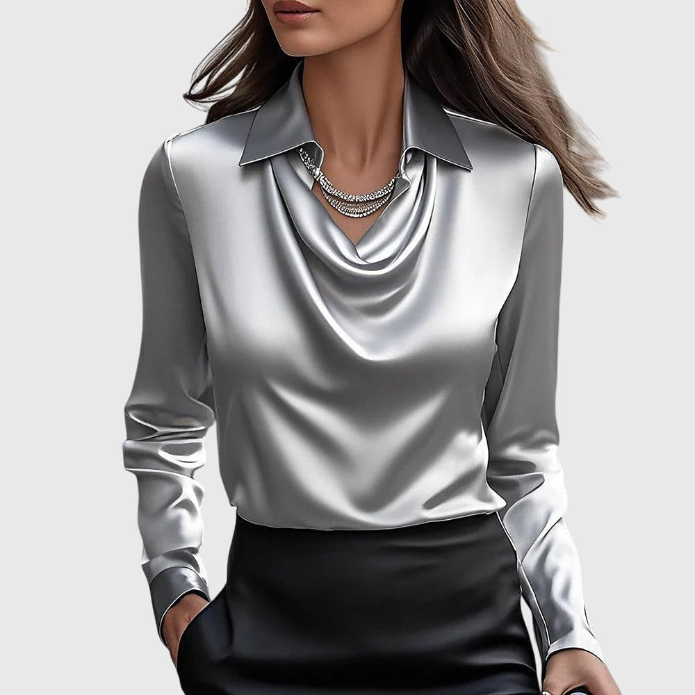 Damen Satin-Bluse in Silbergrau mit Wasserfallausschnitt, Kragen und langen Ärmeln, dazu schwarzer Rock und Strasskette.
