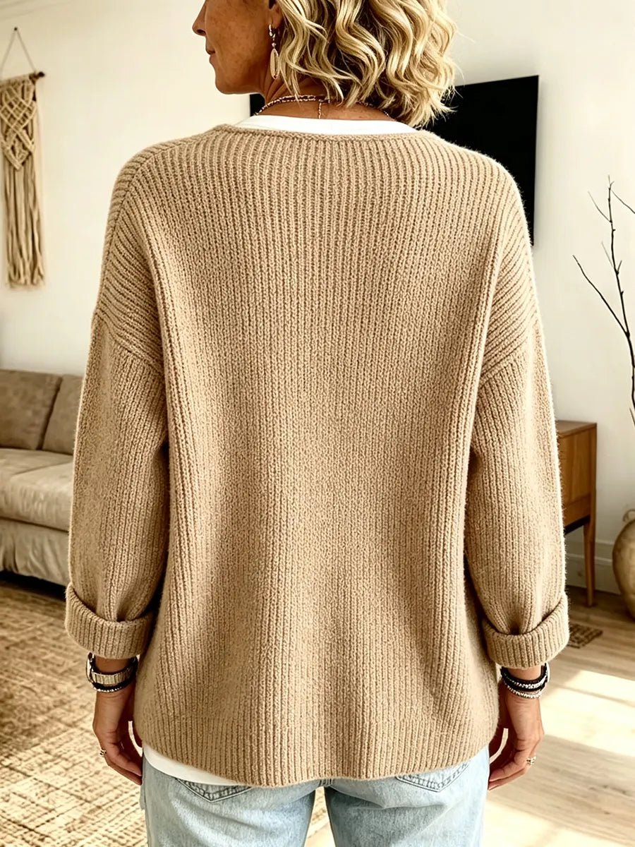 Rückansicht der camelfarbenen Strickjacke an einer Frau, die Rippenstruktur und umgeschlagene Ärmel sind gut zu sehen 2