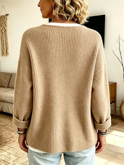 Rückansicht der camelfarbenen Strickjacke an einer Frau, die Rippenstruktur und umgeschlagene Ärmel sind gut zu sehen 2