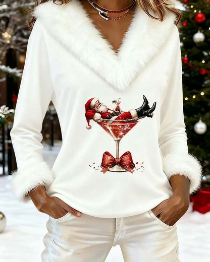 Weißes Oberteil mit Santa-Druck, vor einem geschmückten Weihnachtsbaum im Schnee fotografiert 6