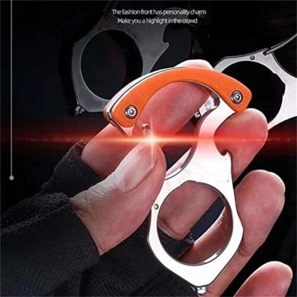 Hand hält den Karabiner-Schlüsselanhänger aus Edelstahl mit orangefarbenem Griffstück zwischen den Fingern, Hintergrund dunkel mit rotem Lichteffekt. 1
