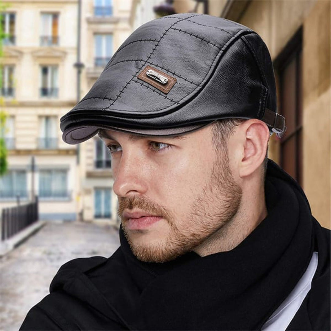 Mann mit schwarzer Leder-Schiebermütze, gesteppt, modisch, urbaner Hintergrund.