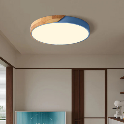 Blaue runde Deckenleuchte mit Holzsegment leuchtet an der Decke eines Raums mit dunklen Holzrahmen 2