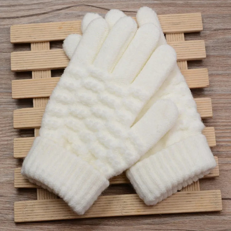 Weiße gestrickte Handschuhe auf Holzunterlage, Wintermode, warme Accessoires, Strickmuster.