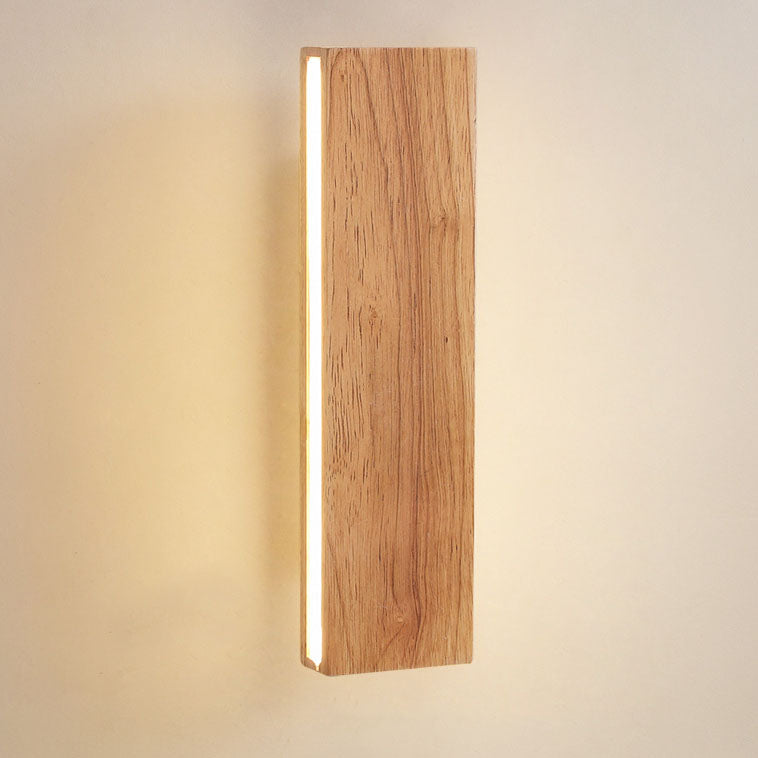 Nahaufnahme der senkrechten Holz-Wandleuchte mit deutlicher Holzmaserung und leuchtendem LED-Streifen an der linken Seite.