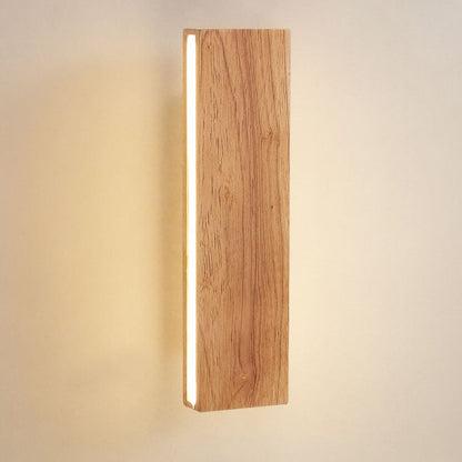 Nahaufnahme der senkrechten Holz-Wandleuchte mit deutlicher Holzmaserung und leuchtendem LED-Streifen an der linken Seite.