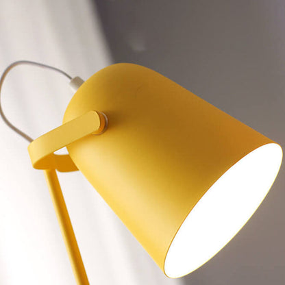 Nahaufnahme des gelben Lampenschirms von schräg unten mit hellem Lichtschein und dem Haltearm am Gelenk. 2