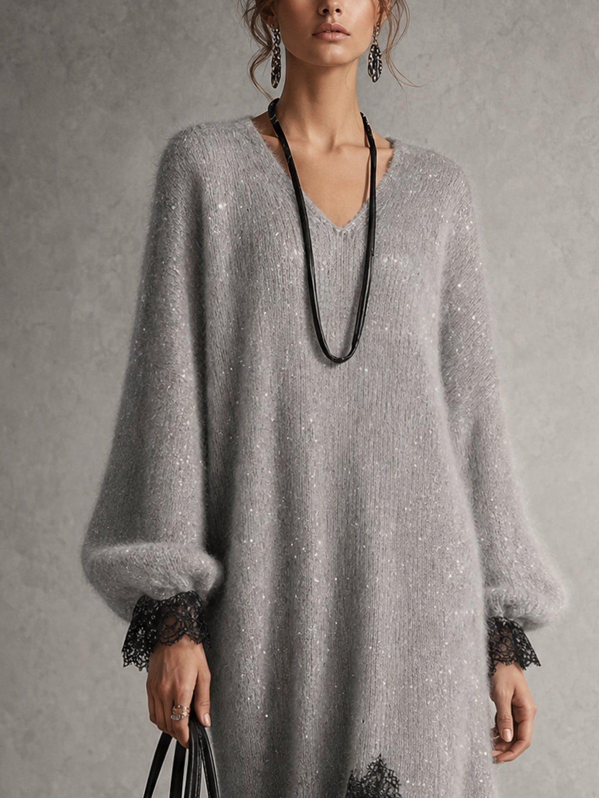 Oberkörper-Detail des grauen Strickkleids mit V-Ausschnitt, Glitzergarn, Puffärmeln und schwarzen Spitzenmanschetten 6
