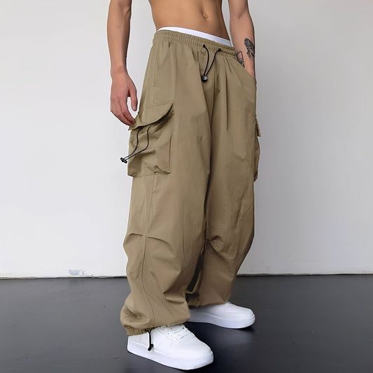 Weite Cargohose in Beige-Khaki, am Model getragen, mit großen Seitentaschen, Kordelzug und Bündchen am Saum 1