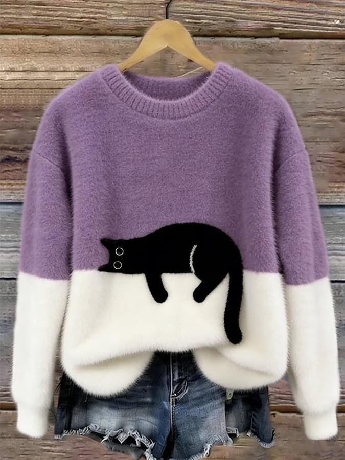 Flauschiger Pullover in Lila mit weißem Saum und aufgenähter schwarzer Katze, am Holzbügel hängend 10