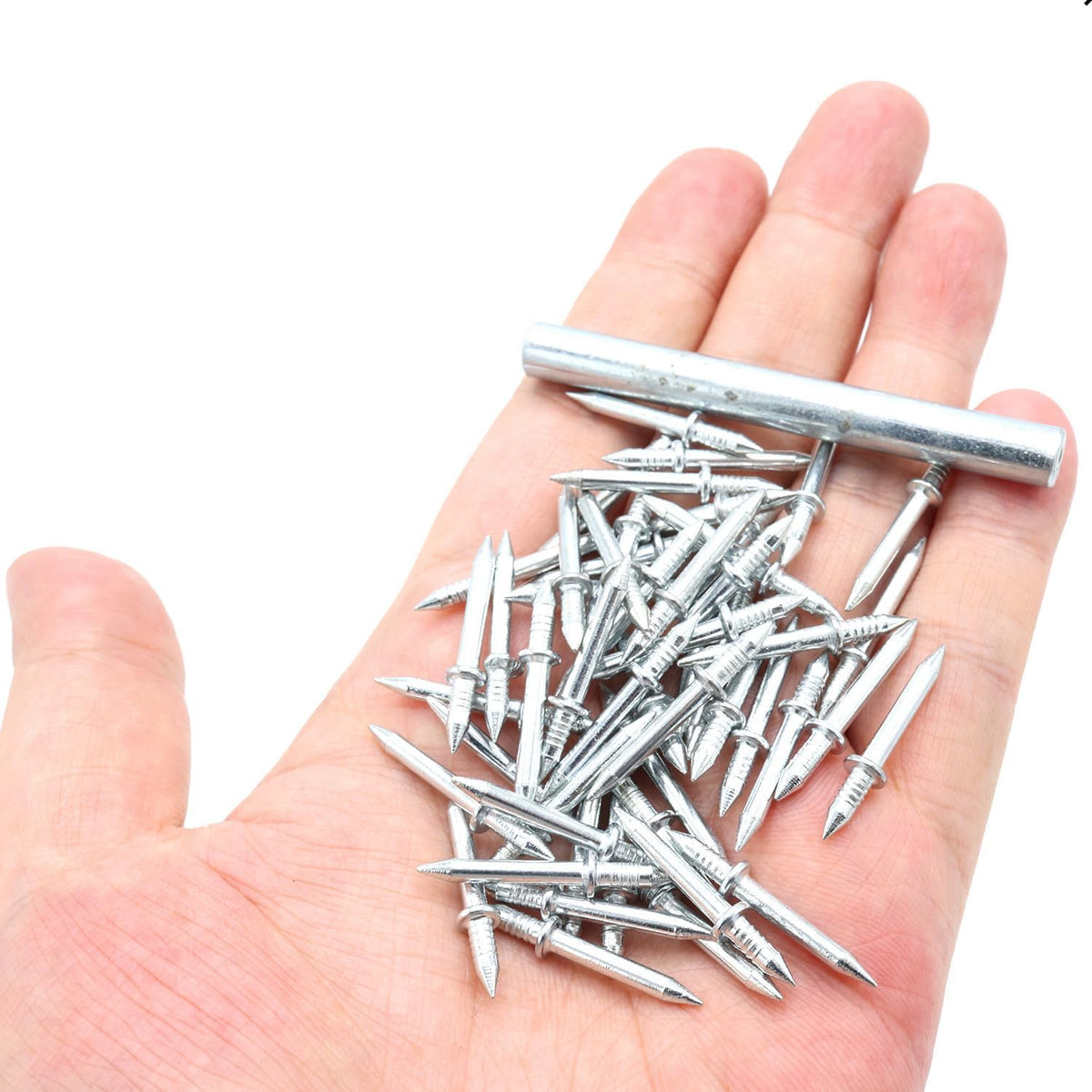 Silberfarbene doppelseitige Nägel und ein metallenes Hülsenwerkzeug auf einer flachen Hand.