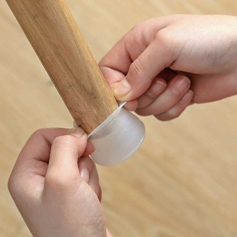 Zwei Hände ziehen eine durchscheinende Silikonkappe über das untere Ende eines hellen Holzbeins, um das Aufstecken zu zeigen. 1
