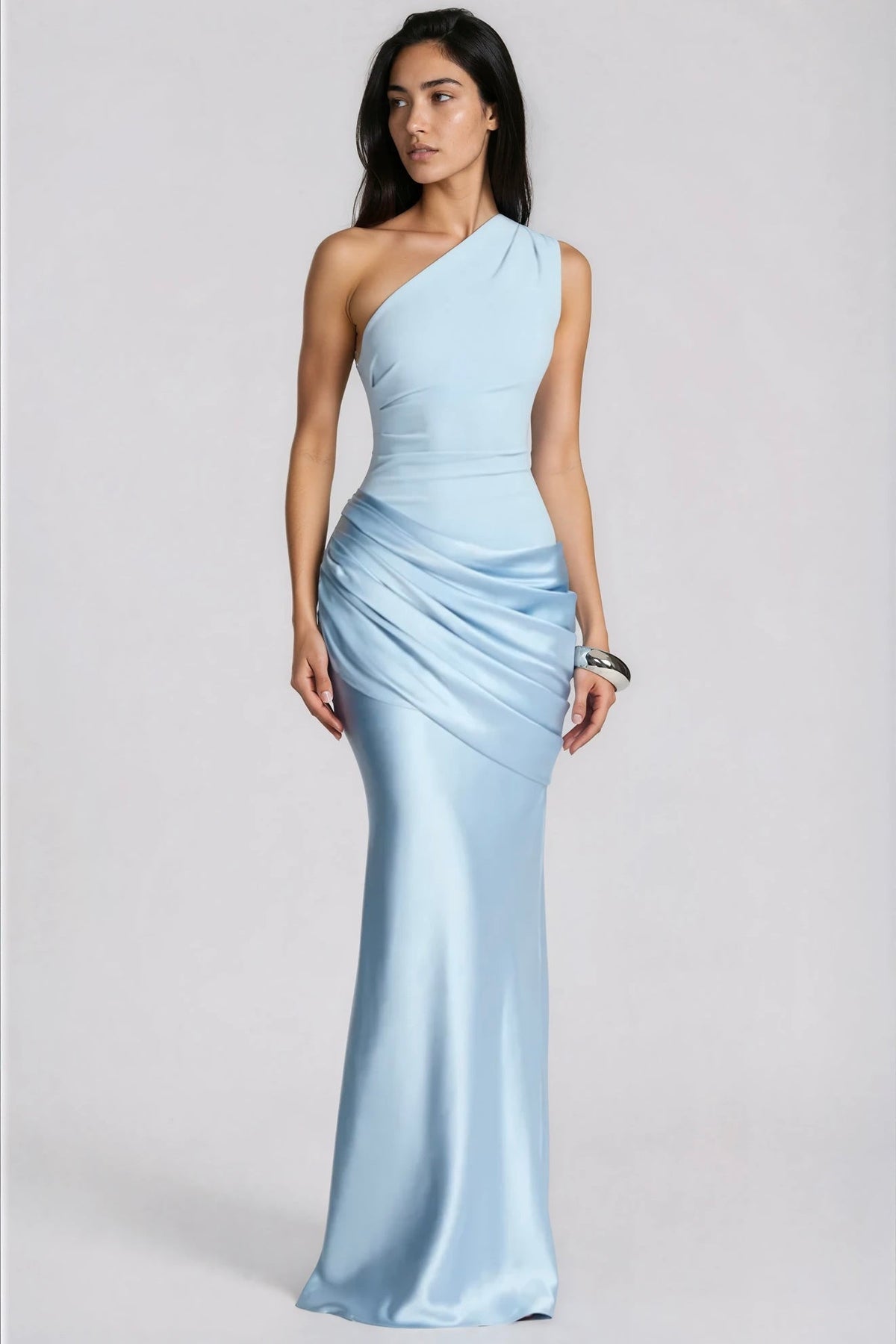 Hellblaues One-Shoulder-Kleid mit gerafftem Satinrock, von einer Frau mit Armreif in der Ganzkörperansicht von vorn getragen. 1