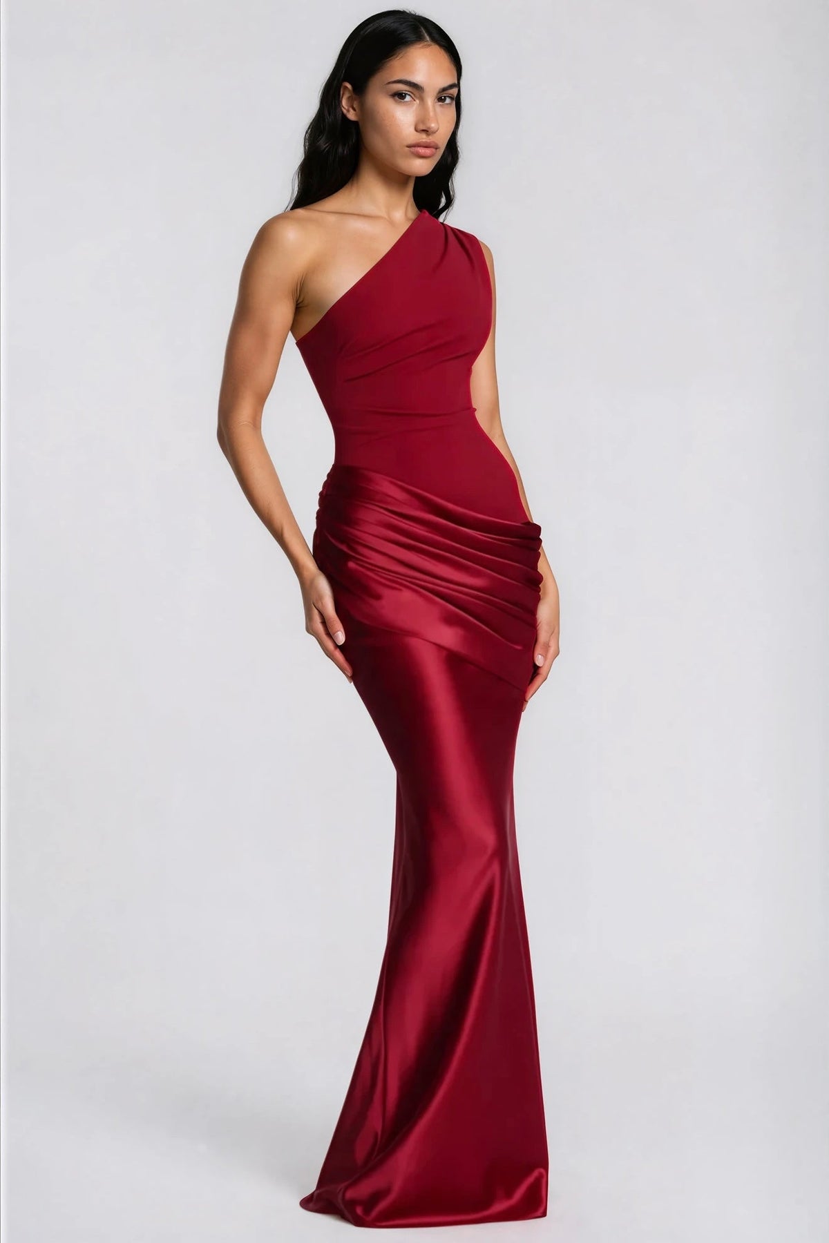 Weinrotes Maxikleid in seitlicher Dreiviertelansicht, die Raffung am Satinrock und der körpernahe Schnitt mit Meerjungfrau-Saum sind zu sehen. 36