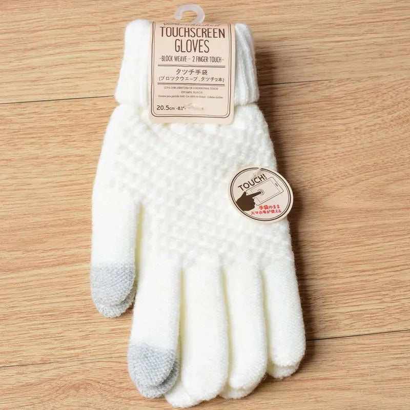 Weiße Touchscreen-Handschuhe aus Wolle mit grauen Fingerspitzen auf Holzuntergrund.