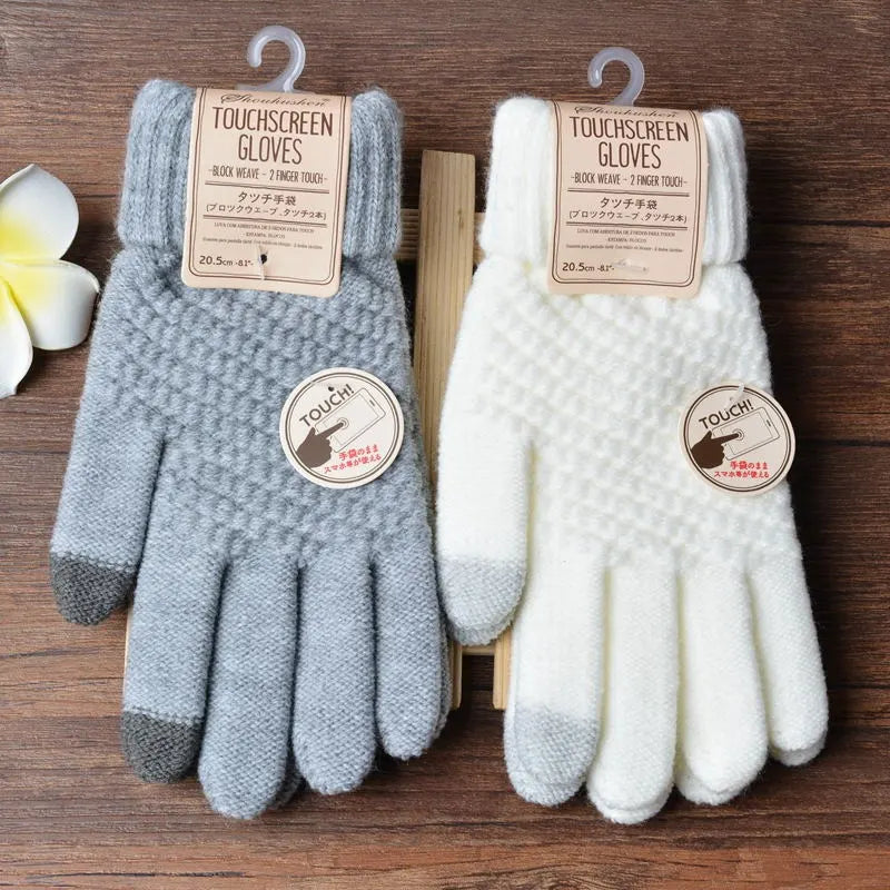 Graue und weiße Touchscreen-Handschuhe aus Wolle, ideal für Winter, auf Holztisch.