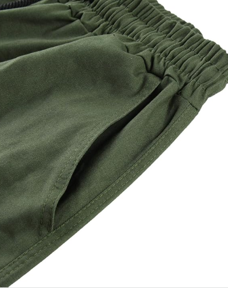 Nahaufnahme von elastischem Bund und seitlicher Eingrifftasche einer olivgrünen Hose mit sichtbaren Nähten