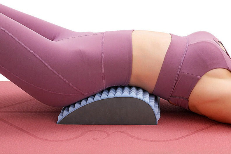 Frau in lila Sportkleidung auf Rückendehner, Yoga-Matte, Fitness, Rückenschmerzen Linderung.