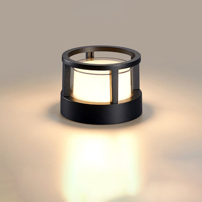 Runde schwarze Leuchte mit offenem Ring statt Deckel und warmweißem Schein, freigestellt auf hellem Hintergrund.