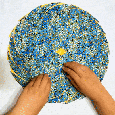 Nähvorlagen für Stoff-Tischsets, Hände ordnen blaue Blumenstoffe mit gelber Raute in der Mitte