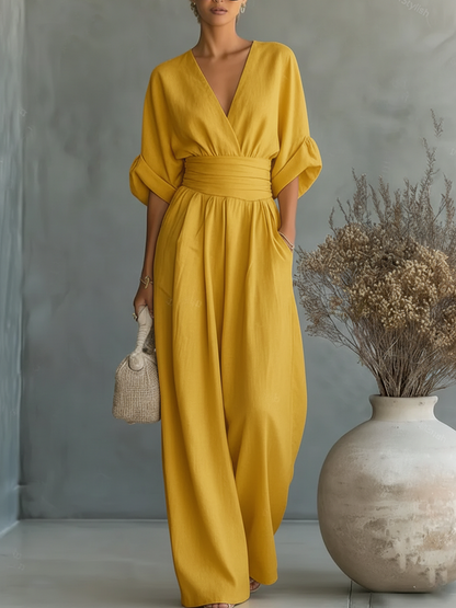 Model im senfgelben Jumpsuit mit tiefem V-Ausschnitt, gerafftem Taillenbund und weit fallendem Bein 5