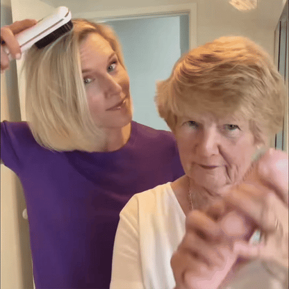 Blonde Frau stylt mit einer weißen Bürste ihr Haar und steht hinter einer älteren Frau mit kurzem Haar. 9