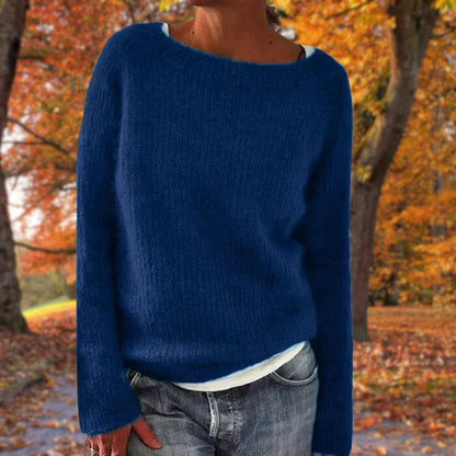 Dunkelblauer Strickpullover mit weichem Flor, getragen über weißem Shirt und grauer Jeans vor bunten Herbstbäumen. 3