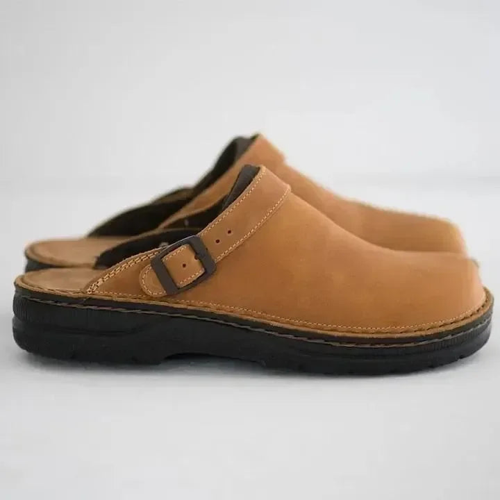 Seitenansicht des Clogs in hellem Cognacbraun mit Schnallenriemen, Ziernähten und kräftiger schwarzer Sohle 5