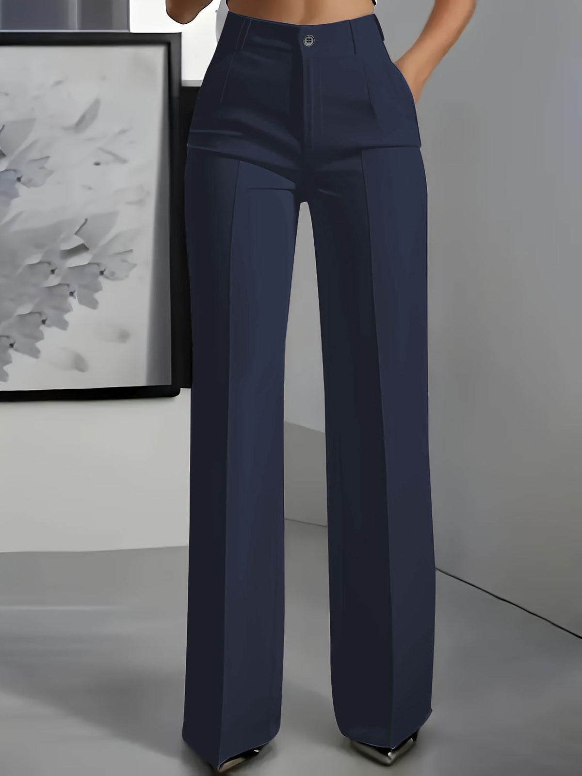 Frontansicht an Model: weit geschnittene Bundfaltenhose in Marineblau mit Knopfverschluss und Bügelfalte, eine Hand in der 1