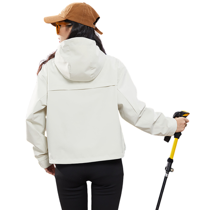 Rückansicht der cremeweißen Jacke mit großer Kapuze und Quernaht am Rücken, Trägerin hält einen Wanderstock 5