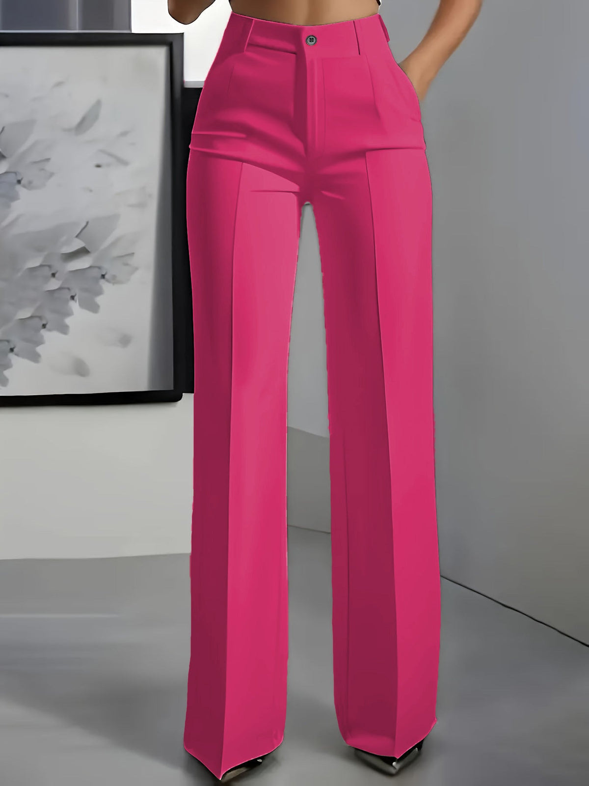 Frontansicht an Model: weit geschnittene Bundfaltenhose in leuchtendem Pink mit Knopfverschluss und Bügelfalte, eine Hand in 4