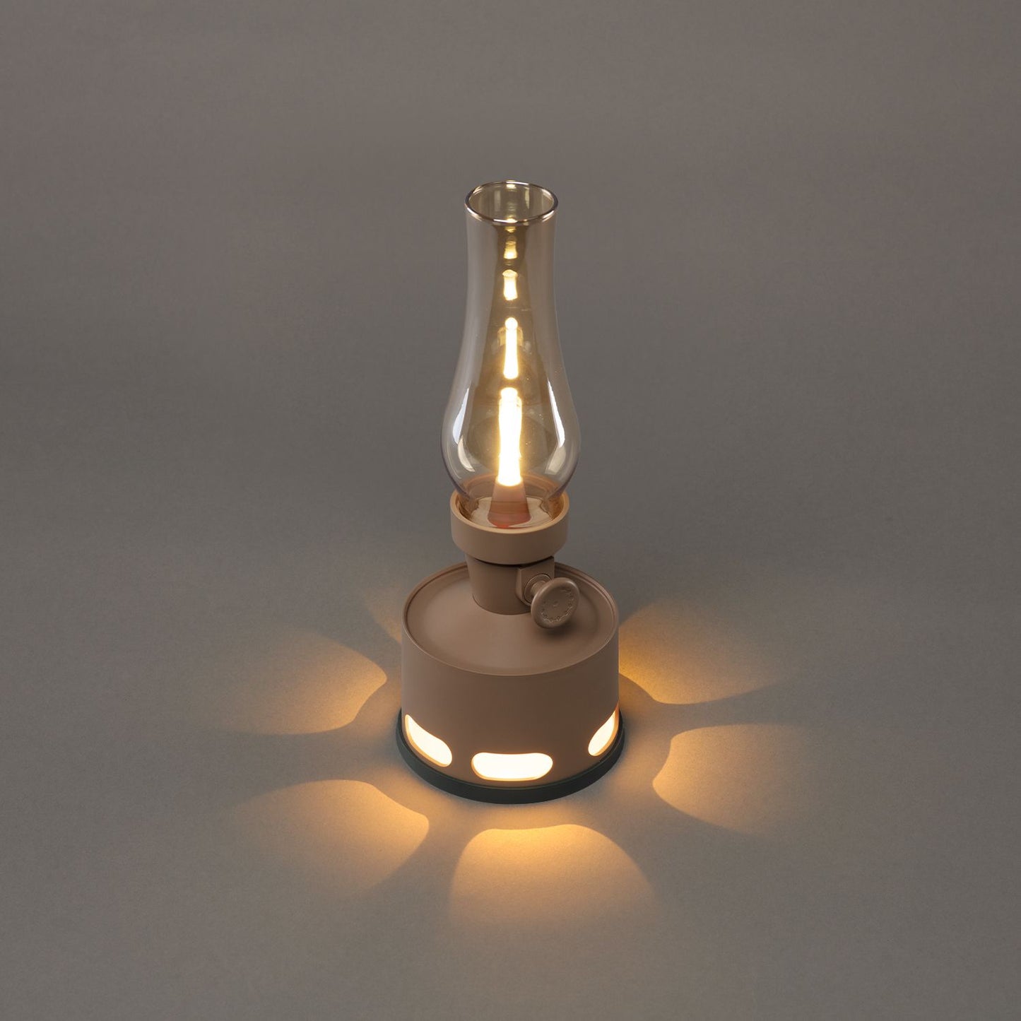 Braune LED-Sturmlampe mit Glaszylinder auf grauem Hintergrund, Vintage-Design, stimmungsvolle Beleuchtung.