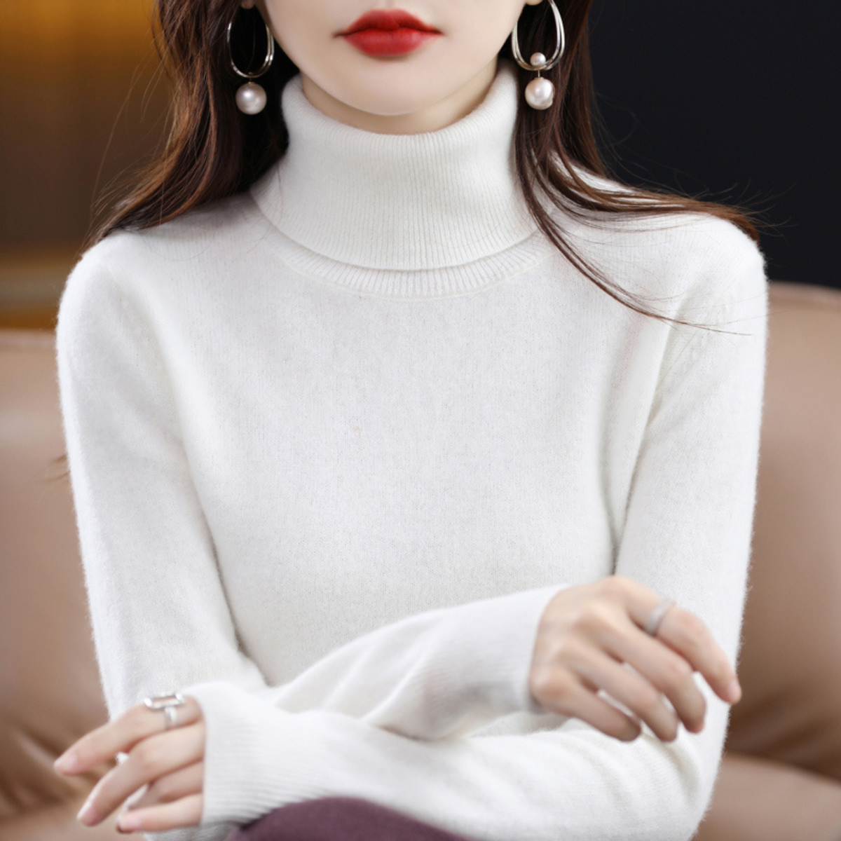 Cremeweißer Rollkragenpullover mit hohem Rippkragen am Model mit dunkler Hose.