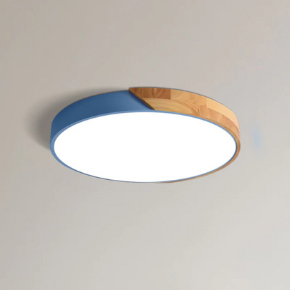Blaue flache Aufbauleuchte mit Holzsegment, freigestellt von schräg unten an einer hellen Decke 12