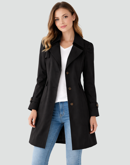 Frontansicht: Model trägt den Trenchcoat in Schwarz offen über weißem T-Shirt und heller Jeans, dreireihige Knopfleiste sichtbar. 1