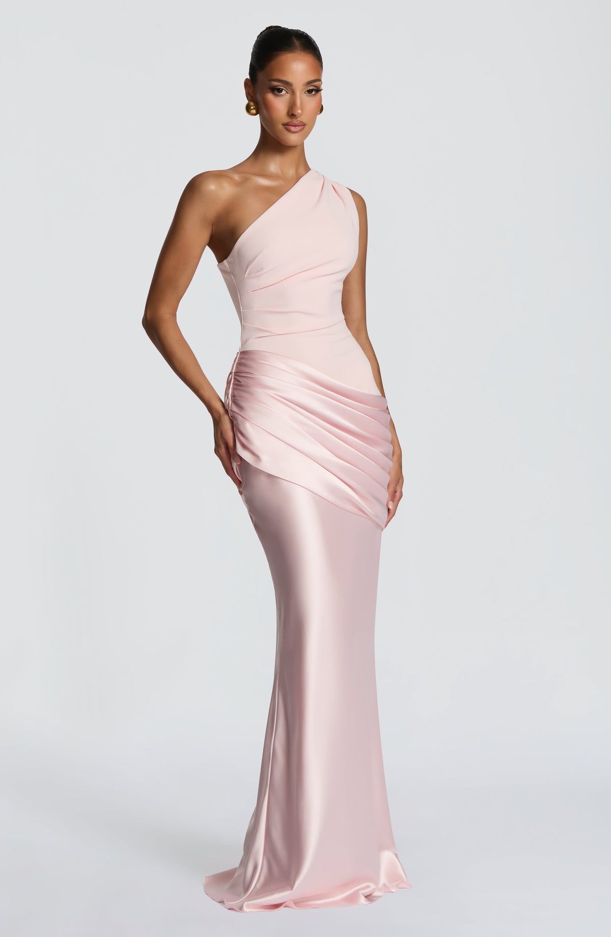 Schräge Ansicht des rosa Maxikleids aus Satin am Model mit Drapierung an der Hüfte.