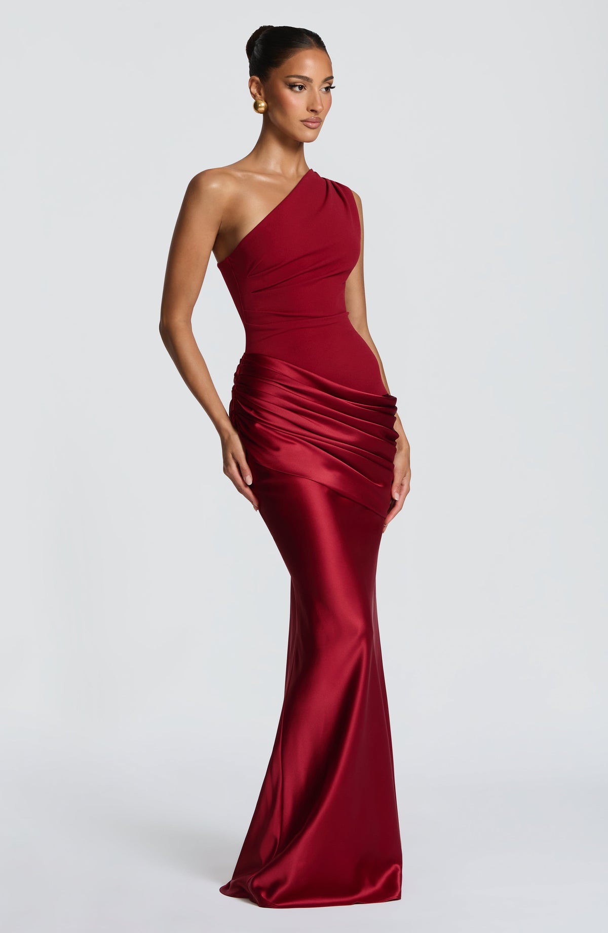 Seitliche Dreiviertelansicht des roten One-Shoulder-Kleids aus Satin mit Drapierung an der Hüfte.