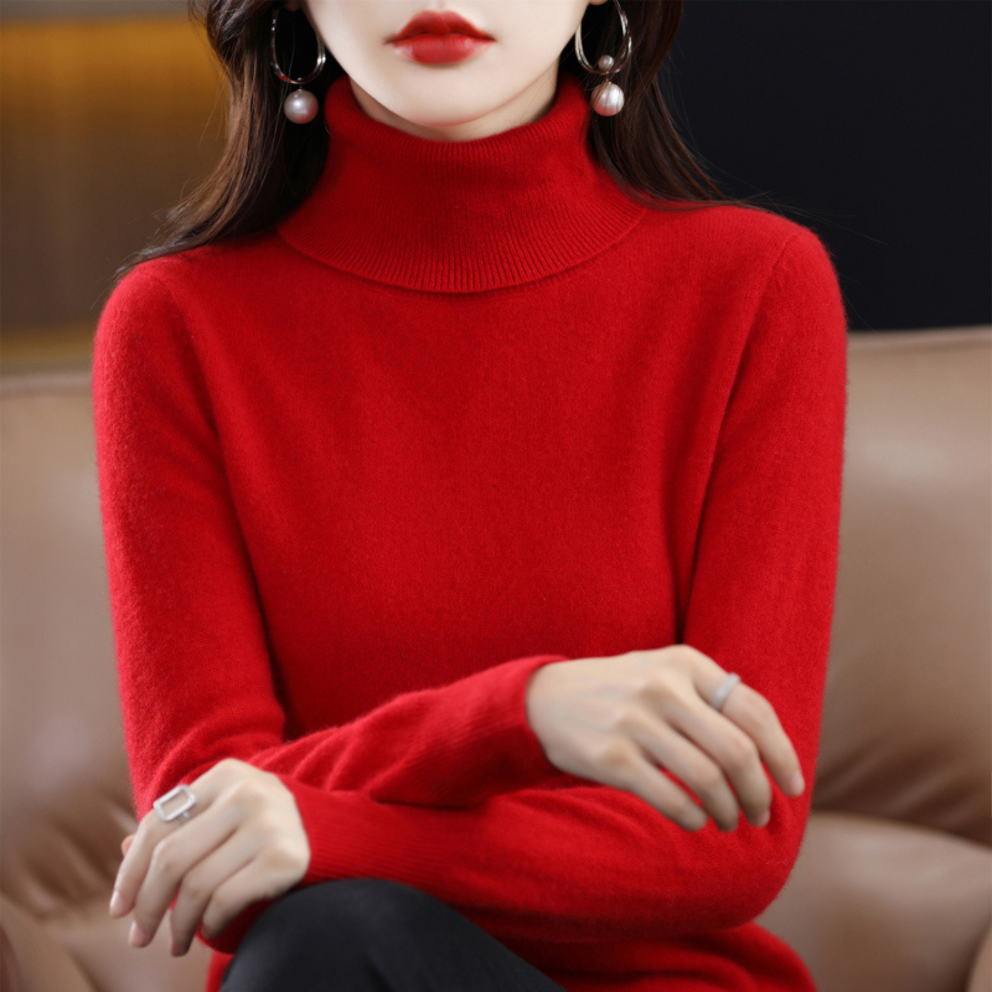 Frau in rotem Rollkragenpullover aus Kaschmir, elegante Ohrringe, stilvolle Wintermode.